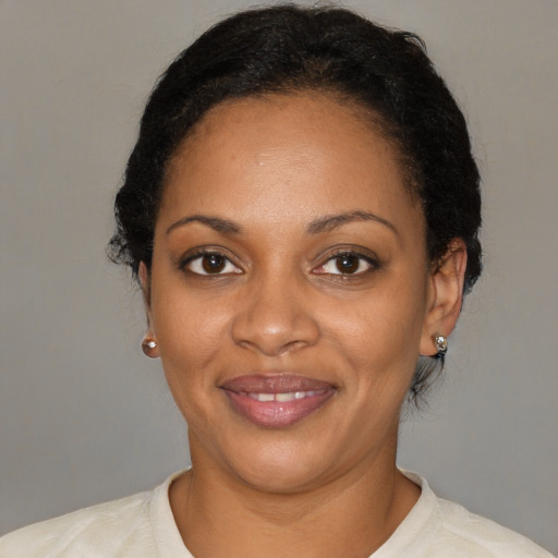 Joyful black adult female with short  black hair and brown eyes