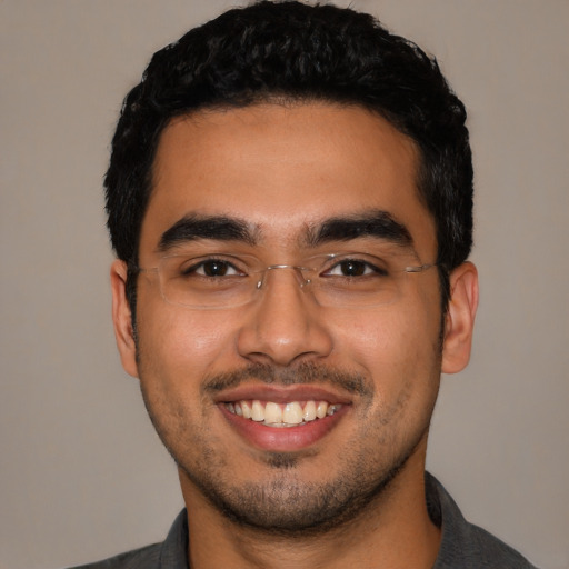 Joyful latino young-adult male with short  black hair and brown eyes