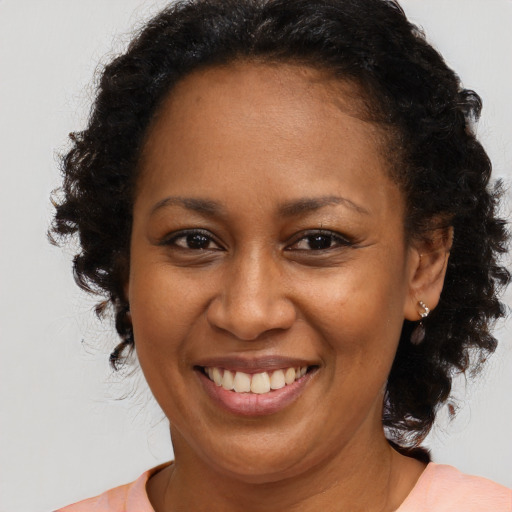 Joyful black adult female with medium  brown hair and brown eyes