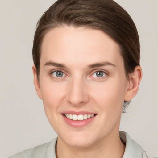 Joyful white young-adult female with short  brown hair and grey eyes