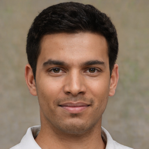 Joyful latino young-adult male with short  black hair and brown eyes