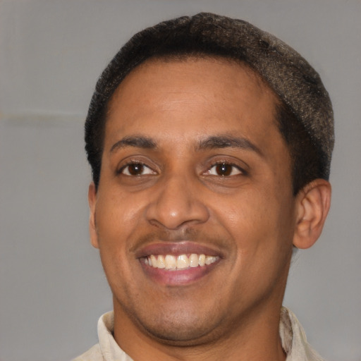 Joyful black young-adult male with short  brown hair and brown eyes