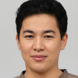 Joyful asian young-adult male with short  black hair and brown eyes