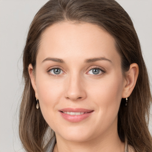 Joyful white young-adult female with long  brown hair and grey eyes