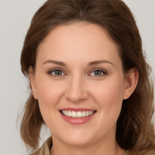 Joyful white young-adult female with long  brown hair and green eyes