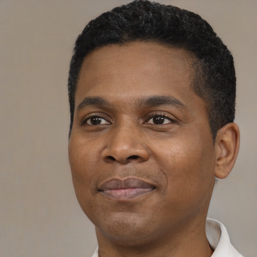 Joyful black young-adult male with short  black hair and brown eyes