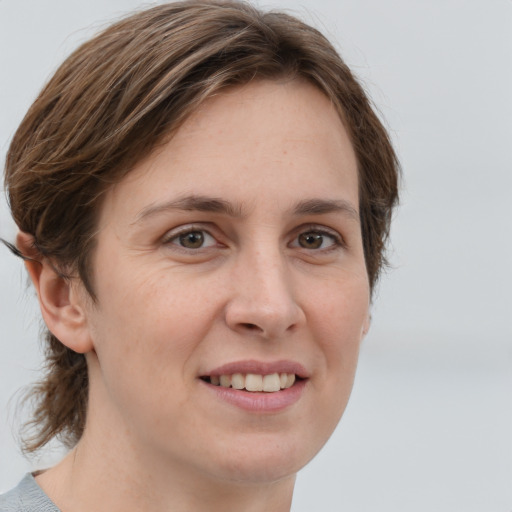 Joyful white young-adult female with medium  brown hair and grey eyes