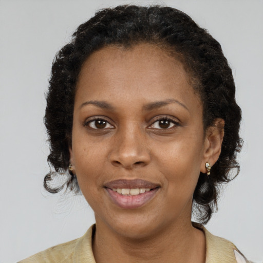 Joyful black young-adult female with short  brown hair and brown eyes