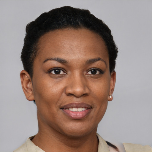 Joyful black young-adult female with short  black hair and brown eyes