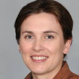 Joyful white young-adult female with medium  brown hair and grey eyes