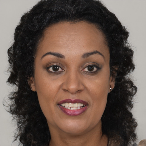Joyful black adult female with long  brown hair and brown eyes
