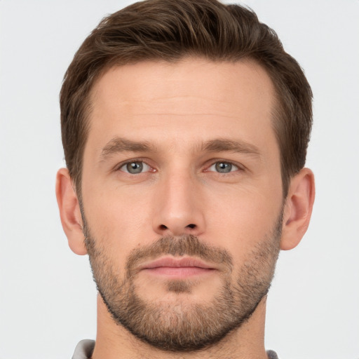 Joyful white young-adult male with short  brown hair and grey eyes