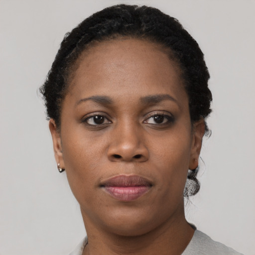 Joyful black young-adult female with short  black hair and brown eyes