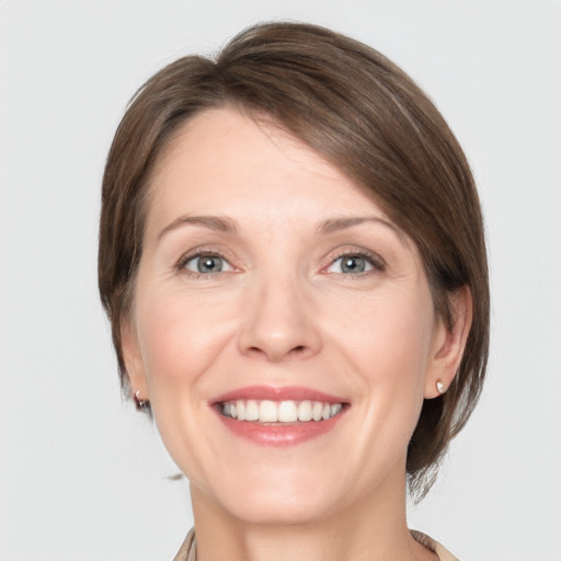 Joyful white young-adult female with medium  brown hair and grey eyes