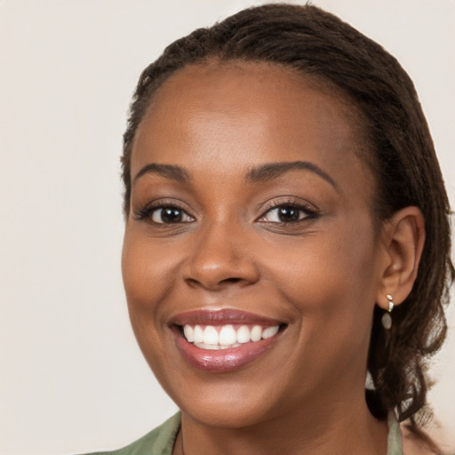 Joyful black young-adult female with long  brown hair and brown eyes