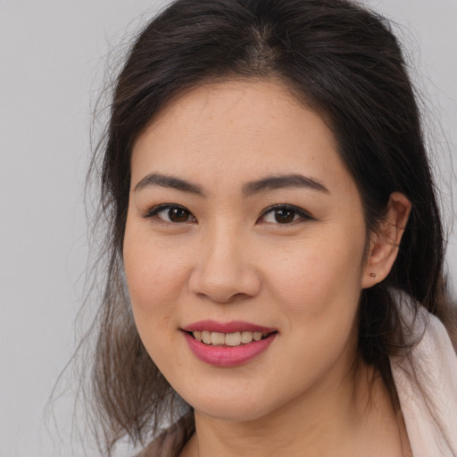 Joyful asian young-adult female with long  brown hair and brown eyes