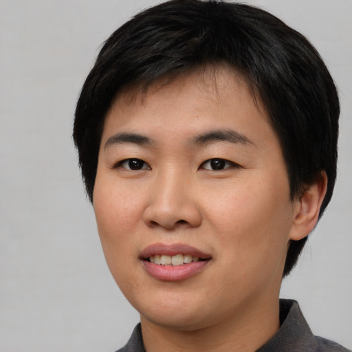Joyful asian young-adult female with short  black hair and brown eyes