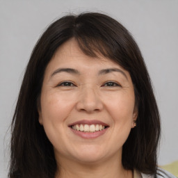 Joyful white adult female with medium  brown hair and brown eyes