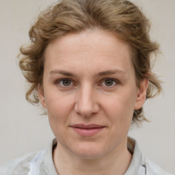 Joyful white adult female with medium  brown hair and grey eyes