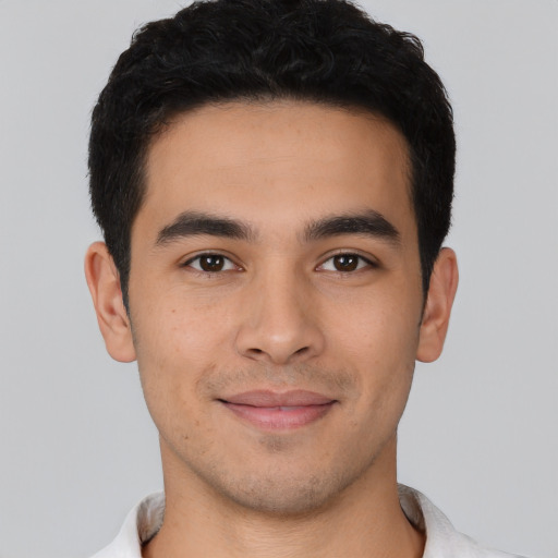 Joyful latino young-adult male with short  black hair and brown eyes