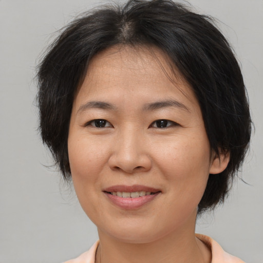 Joyful asian adult female with medium  brown hair and brown eyes