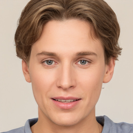 Joyful white young-adult male with short  brown hair and grey eyes