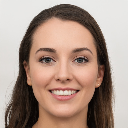 Joyful white young-adult female with long  brown hair and grey eyes