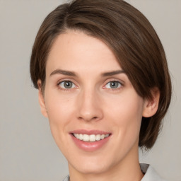 Joyful white young-adult female with medium  brown hair and green eyes