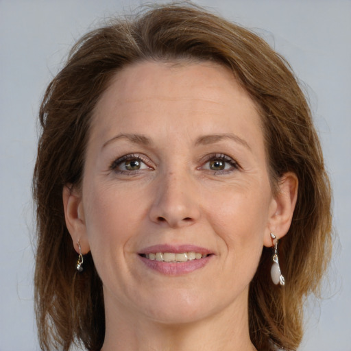 Joyful white adult female with long  brown hair and grey eyes