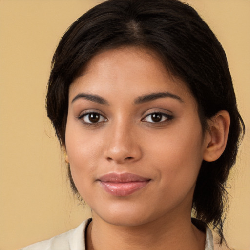 Joyful latino young-adult female with medium  brown hair and brown eyes