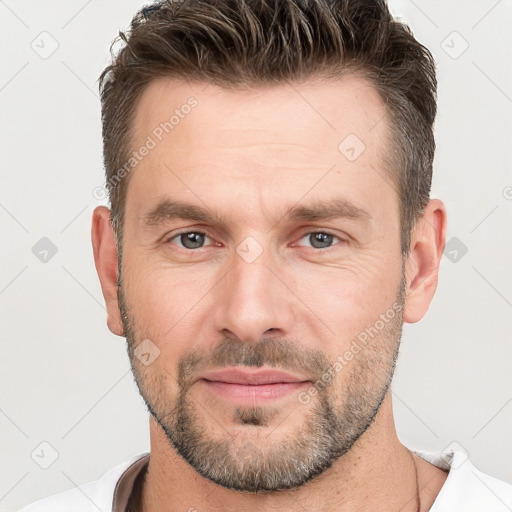 Joyful white adult male with short  brown hair and brown eyes