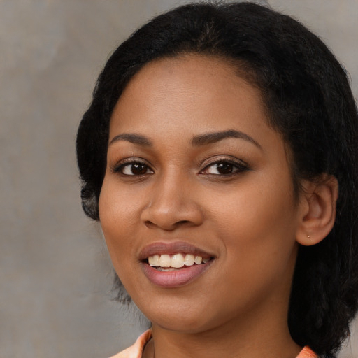 Joyful black young-adult female with medium  black hair and brown eyes