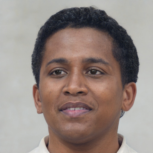 Joyful black young-adult male with short  brown hair and brown eyes