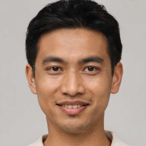 Joyful asian young-adult male with short  black hair and brown eyes