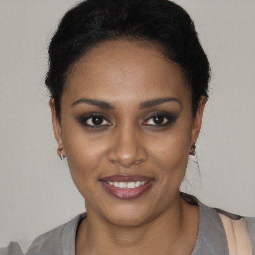 Joyful black young-adult female with short  black hair and brown eyes