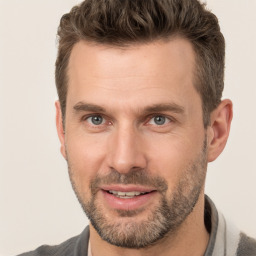 Joyful white adult male with short  brown hair and brown eyes