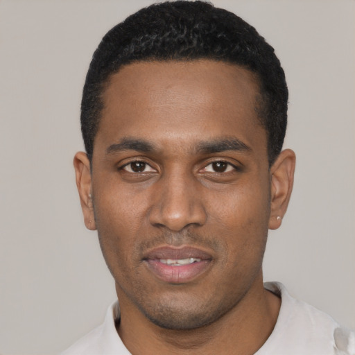 Joyful black young-adult male with short  black hair and brown eyes