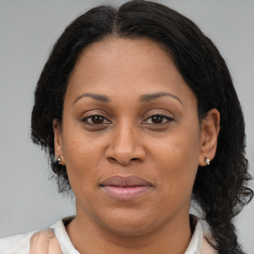 Joyful latino adult female with medium  brown hair and brown eyes
