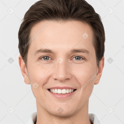 Joyful white young-adult male with short  brown hair and grey eyes