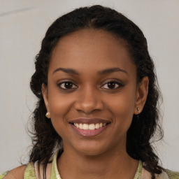 Joyful black young-adult female with long  brown hair and brown eyes