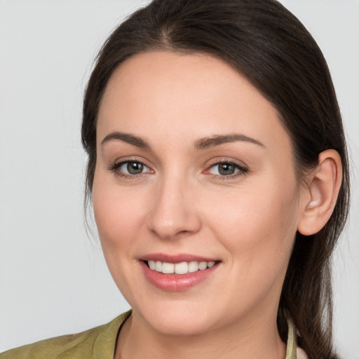 Joyful white young-adult female with medium  brown hair and grey eyes