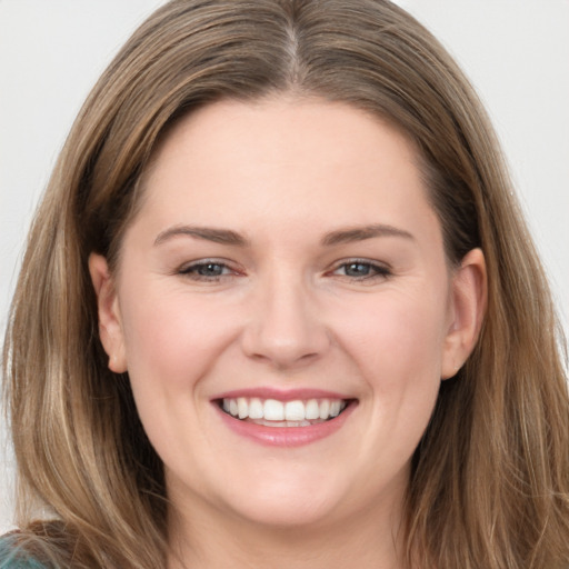 Joyful white young-adult female with long  brown hair and grey eyes