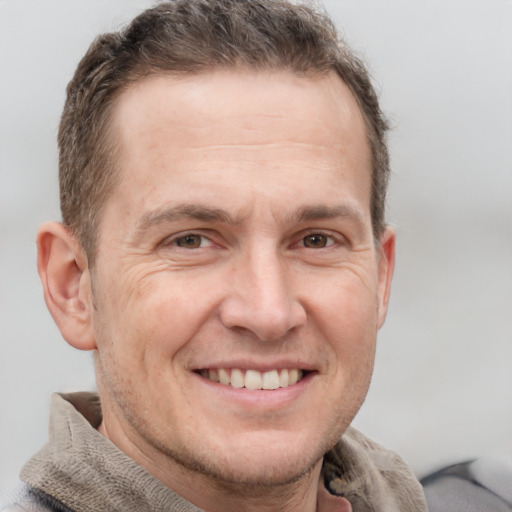 Joyful white adult male with short  brown hair and grey eyes