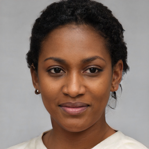 Joyful black young-adult female with short  black hair and brown eyes