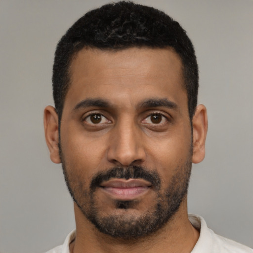 Joyful black young-adult male with short  black hair and brown eyes