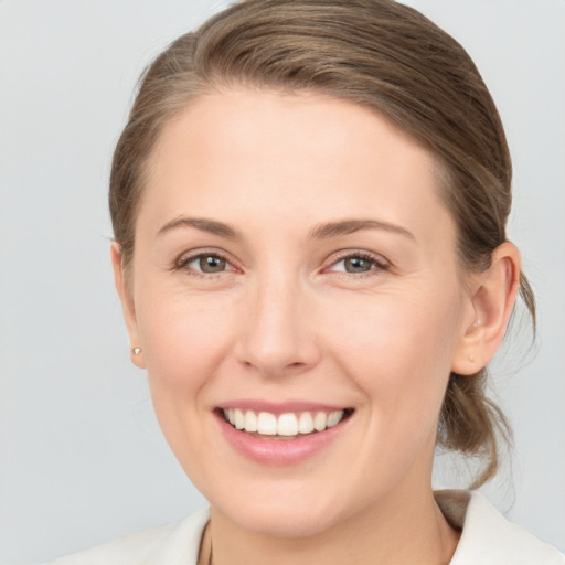 Joyful white young-adult female with medium  brown hair and grey eyes