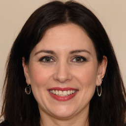 Joyful white adult female with long  brown hair and brown eyes