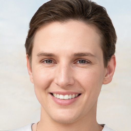 Joyful white young-adult female with short  brown hair and grey eyes