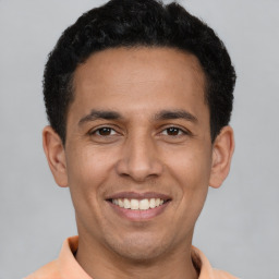 Joyful latino young-adult male with short  brown hair and brown eyes