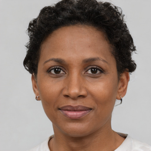 Joyful black adult female with short  brown hair and brown eyes